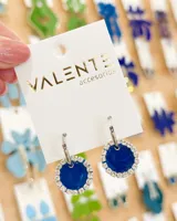 Aros colgantes con aro de acero plateado y dije circular azul con borde de strass.