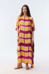 Kaftan largo de modal con escote redondo, mangas cortas y diseño amplio de caída fluida, con estampado geométrico en tonos amarillo y fucsia.