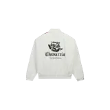Campera Adidas Chavarria Woven Track Jacket color blanco off-white, con cierre frontal y cuello alto. Cuenta con franjas laterales en las mangas en tonos oscuros y detalles bordados en el pecho que incluyen una rosa y el logo clásico de Adidas.
