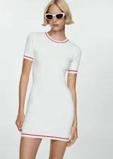Vestido corto de tejido de punto fino, color blanco con detalles de líneas en contraste color rojo en cuello, mangas y ruedo. Presenta cuello redondo, mangas cortas y un diseño entallado al cuerpo.