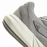 Championes deportivos Adidas modelo Lightblaze, color gris con detalles en blanco y negro. Presentan una estructura de malla transpirable con refuerzos de gamuza sintética, cordones blancos y una entresuela gruesa con tecnología Lightstrike para mayor amortiguación.