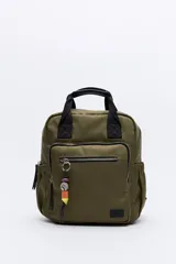 Mochila de nylon color verde militar con asas superiores reforzadas y tiras regulables. Cuenta con un bolsillo frontal con cierre metálico y un detalle colgante de cuentas de colores. Los laterales tienen bolsillos elastizados y el compartimento principal tiene cierre.
