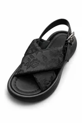 Sandalias de plataforma color negro, con tiras cruzadas de tela estampada en blanco y negro, tira trasera ajustable con hebilla metálica y suela chunky de goma.