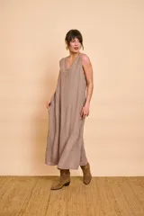 Vestido largo de lino color tostado, tipo túnica y de corte suelto, con escote en V decorado con detalles tejidos y lentejuelas.
