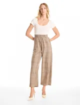 Enterito de diseño combinado con remera de cuello redondo y manga corta en color crema, integrada a un pantalón de corte recto y tiro alto con estampado a cuadros. Presenta cintura elastizada y bolsillos laterales inclinados.
