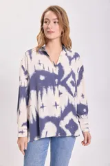 Camisa de manga larga con botones y cuello clásico, con estampado tie-dye en tonos azul y blanco.
