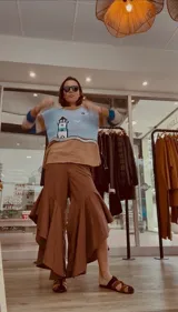 Pantalón de jean azul oscuro con diseño fluido y volados en las piernas.