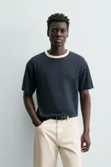 Camiseta de manga corta y cuello redondo, color azul marino, con ribete de contraste en color crema alrededor del cuello.