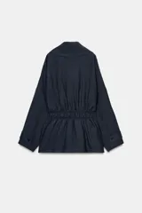 Trench corto de Zara, confeccionado en mezcla de lyocell, color verde militar. Presenta cuello solapa, manga larga con hombro caído y puños con trabilla. Incluye bolsillos delanteros de plastrón, cierre frontal cruzado con botón y cinturón de lazada en el mismo tejido.