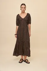 Vestido largo celeste con estampado botánico en tonos marrones, escote en V, mangas cortas abullonadas y falda con volado en el bajo.