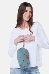 Estuche necessaire de lona tipo canvas color crudo con estampado de flores en color lila. Tiene cierre superior con tirador de cuero marrón y manija lateral de cuero marrón.