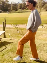 Pantalón de cuero ovino color camel, corte mom fit con tiro semi alto y tajos inferiores.