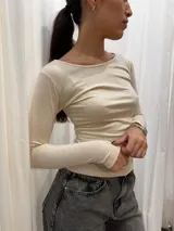 Remera manga larga básica de algodón color beige, de corte ajustado y escote redondo amplio.