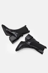 Bota tipo chelsea de cuero color bordó, con paneles elásticos laterales negros, puntera cuadrada y taco bloque negro.