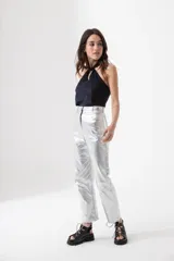 Pantalón plateado de tiro alto, corte recto y largo al tobillo.