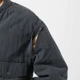 Campera bomber azul petróleo acolchada con cuello redondo, cierre con botones a presión, bolsillos con solapa y puños y cintura elásticos.