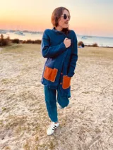 Saco de lana azul con bolsillos de cuero color naranja, botones al frente y tajos a los costados.