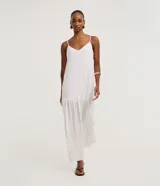 Vestido largo evasé de crepé color blanco con estampa de lunares negros, escote en V, tirantes finos ajustables y detalle de volados fruncidos en el ruedo.