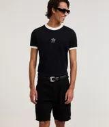 Bermuda slim de sarga color negro para hombre, de corte ajustado, con cierre de botón y cremallera, y bolsillos funcionales.