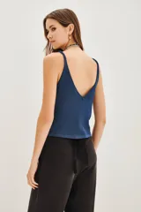 Musculosa de punto con acabado metalizado, escote en V y breteles anchos. Presenta un diseño liso y entallado.