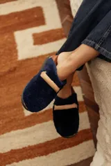 Mocasines de piel sintética azul marino con detalle de tira en el empeine en tono tostado y suela plana.