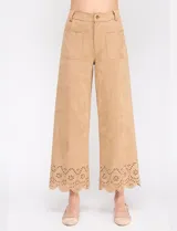 Pantalón de tiro alto color beige, marca Allie Rose, confeccionado en tela símil gamuza. Presenta pretina con pasadores, botón y cierre, bolsillos delanteros y ruedo con diseño calado. De pierna ancha.