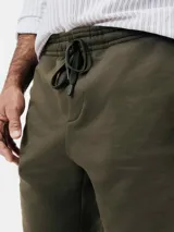 Bermuda de algodón color verde militar, con cintura elastizada y cordón de ajuste.