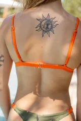 Bikini colaless de lycra estampada con motivos de hojas y flores en tonos verde militar, naranja y marrón.