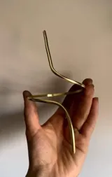 Brazalete de bronce dorado, abierto y ajustable para usar en el brazo o antebrazo.