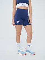 Calza corta tipo biker azul marino, de tiro alto, con el escudo del Club Nacional de Football estampado en la pierna derecha.
