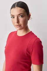 Remera blanca de manga corta y cuello redondo, con calce ajustado al cuerpo y diseño liso y minimalista.