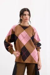 Sweater holgado con diseño de rombos en tonos marrón, negro y rosado, con detalles de lurex en las líneas divisorias. Presenta cuello redondo, mangas largas con puños acanalados y un corte relajado.