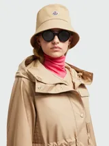 Gorro tipo bucket de algodón color beige, con diseño clásico de ala corta y logo de la marca aplicado en el frente.