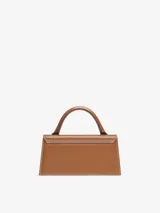 Bolso de mano color marrón, de cuero, con asa corta reforzada, cierre magnético y correa ajustable extraíble. Tiene un bolsillo interior, logotipo y herrajes metálicos dorados.
