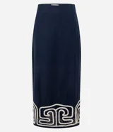 Pollera recta de largo midi en color azul marino, confeccionada en tejido de cambraia de algodón y lino. Presenta un bordado geométrico en color crema en el ruedo, cierre de cremallera y abertura central en la parte trasera.