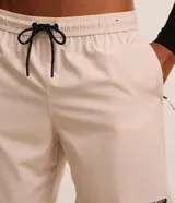 Bermuda deportiva Get Over de color beige, con cintura elástica, cordón ajustable contrastante, bolsillo trasero y pequeña estampa localizada.