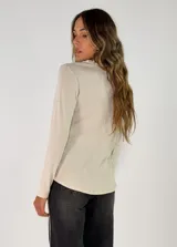 Remera de manga larga color azul, con cuello redondo adornado con un detalle de textura desflecada o peluda en el borde.