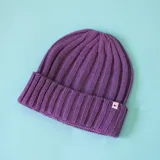 Gorro tipo beanie de tejido de punto acanalado en color violeta, con doblez en el borde y etiqueta pequeña con logo N+.