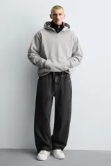 Zapatillas deportivas blancas de caña baja, con detalle de color negro en el talón y suela con volumen.