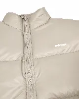 Campera puffer de nylon acolchada color beige, con cuello alto y cierre frontal. Presenta el logo de la marca Mistral estampado en el pecho.