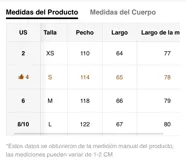 Chaqueta negra de efecto cuero, estilo bomber o motociclista, con cuello alto abotonado y cierre frontal asimétrico. Presenta detalles de costuras verticales y hombreras pequeñas. El bajo es elástico.