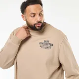Buzo de cuello redondo en color beige, confeccionado en felpa ligera. Presenta un estampado gráfico en el pecho con la inscripción 'East Kensington Philadelphia' y puños y ruedo acanalados.