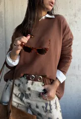 Sweater de punto color chocolate, de corte holgado y manga larga, con cuello redondo.