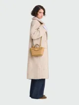 Cartera tipo tote en tamaño extra pequeño, confeccionada en cuero de color verde oliva. Presenta una estructura rígida con asas cortas redondeadas y un cierre de solapa con broche metálico dorado grabado con el logo de la marca.