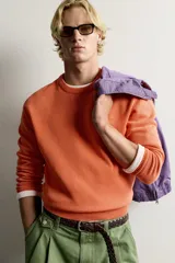 Jersey relaxed fit de punto tejido en hilatura de algodón con cuello redondo, manga larga y efecto lavado. Presenta un pequeño bordado en el delantero y acabados en rib. Colección especial Fruit of the Loom x Zara.