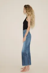 Jeans de tiro alto con diseño de cinco bolsillos, trabillas para cinturón y cierre frontal con cremallera y botón metálico.