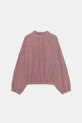 Chaqueta de manga larga con estampado de cuadros vichy en tonos marrón y blanco, cuello camisero, cierre frontal con botones y bajo ajustable con cordón.