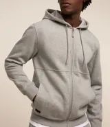 Buzo deportivo negro con capucha, cierre frontal con cremallera, bolsillos laterales y puños ajustados. Confeccionado en tejido de algodón y poliéster.