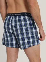 Pack de tres bóxers de algodón con cintura elástica con logo Tommy Hilfiger. Incluye un bóxer a cuadros azules y blancos, un bóxer negro con lunares blancos y un bóxer a cuadros verdes y azules.
