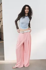 Pantalón ancho de tiro medio, color rosa pálido, con pinzas delanteras y bolsillos laterales y traseros.